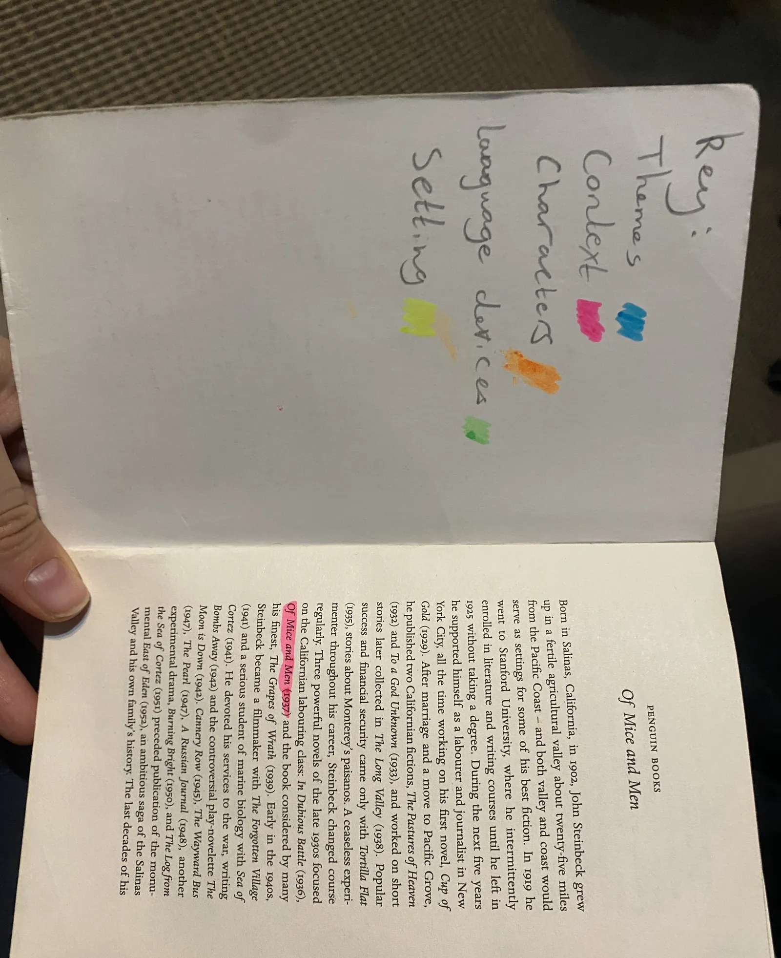 A copy of Of Mice and Men with coloured tabs and a handwritten list of themes and characters