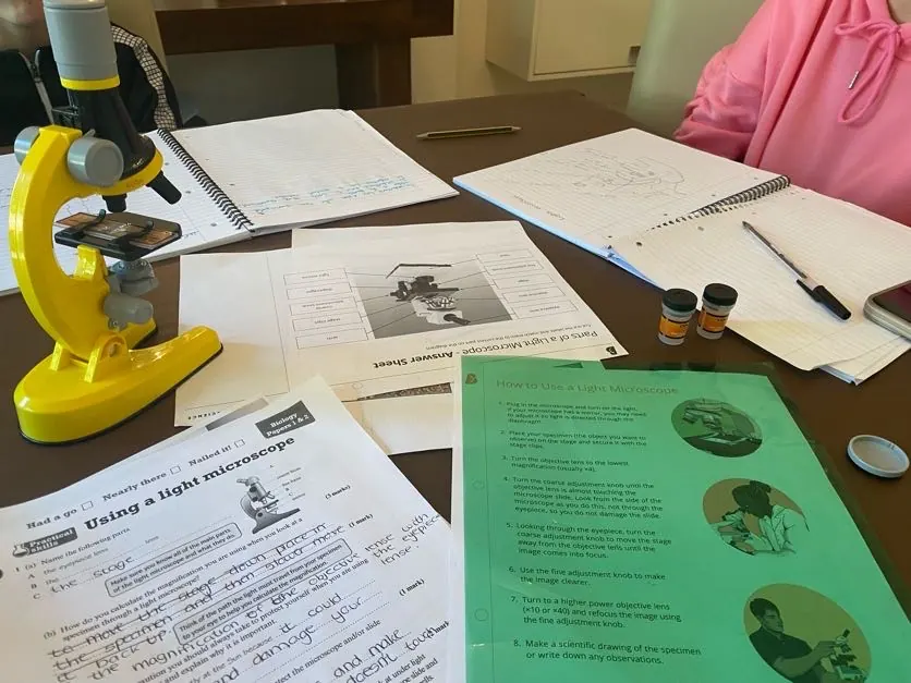 A toy microscope beside worksheets on using a light microscope